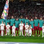 لاعبو منتخب البرتغال يصطفون خلف أطفال مرافقين على أرض الملعب أمام مدرجات مكتظة بالجماهير