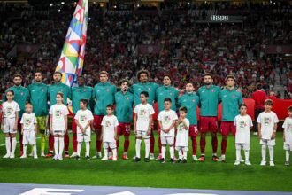 لاعبو منتخب البرتغال يصطفون خلف أطفال مرافقين على أرض الملعب أمام مدرجات مكتظة بالجماهير