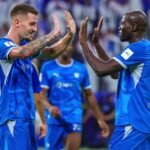لاعبان من الهلال يرفعان أيديهما لتبادل التحية على أرض الملعب أمام المدرجات